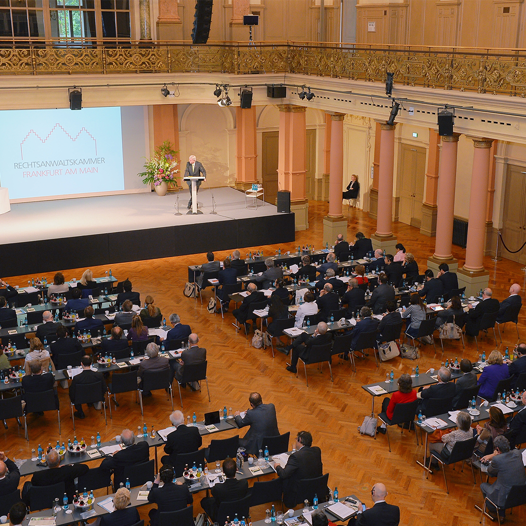 Im Festsaal findet eine Tagung statt. Die Bestuhlung ist parlamentarisch angeordnet und die Besucher hören einem Redner auf der Bühne zu.